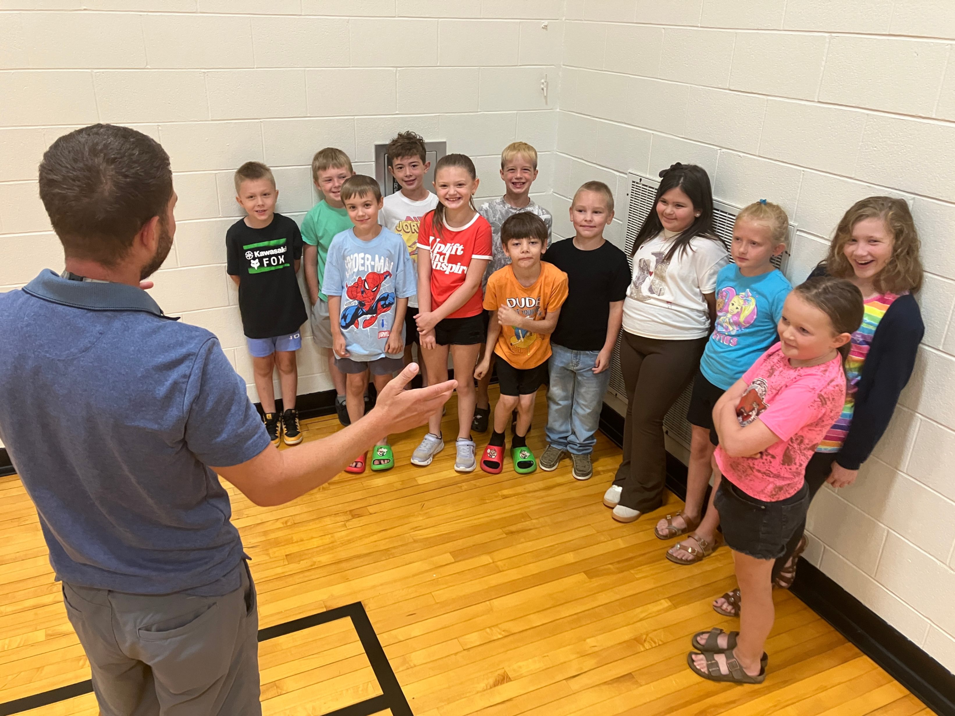 Third grade teacher Vinnie Esposito speaks with his incoming third grade students in the gym at Hickory Grove.